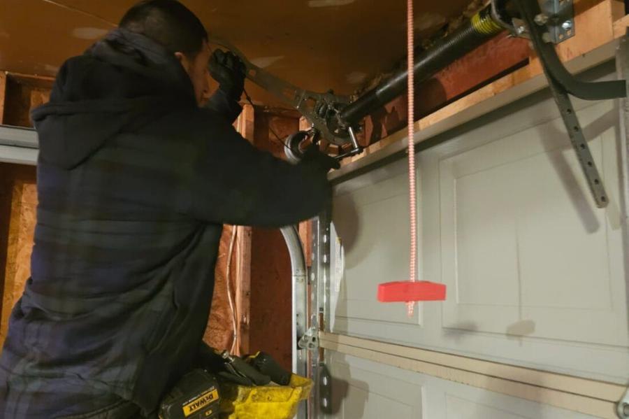 DPS Garage Doors technician performing a garage door maintenance tune-up on the spring and hardware in the GTA