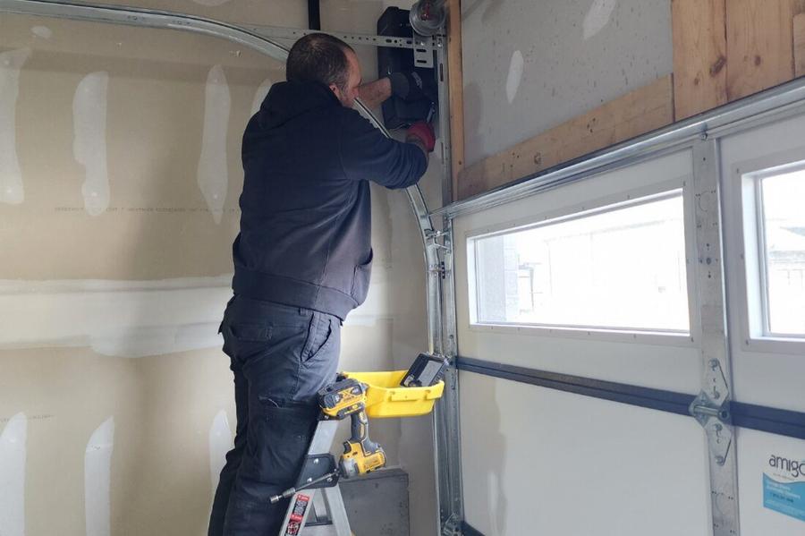 DPS Garage Doors technician repairing a garage door track and opener in the GTA